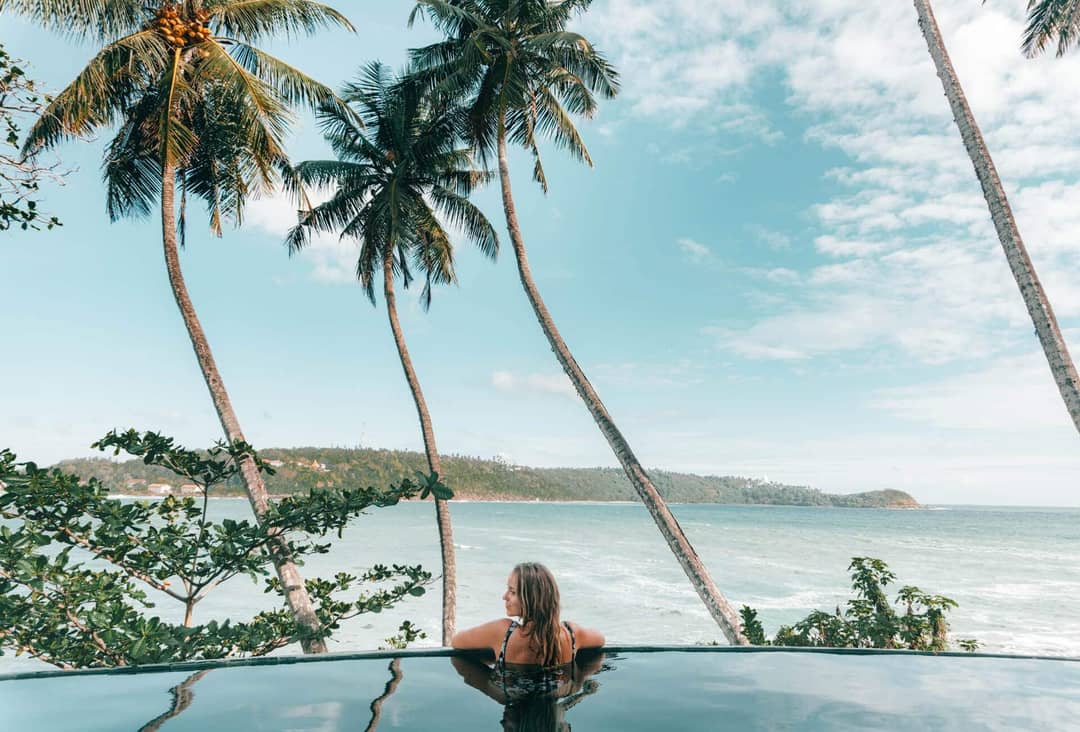 things to do unawatuna sri lanka infinity pool luna terrace woman enjoying herself overlooking the blue ocean waves roll in