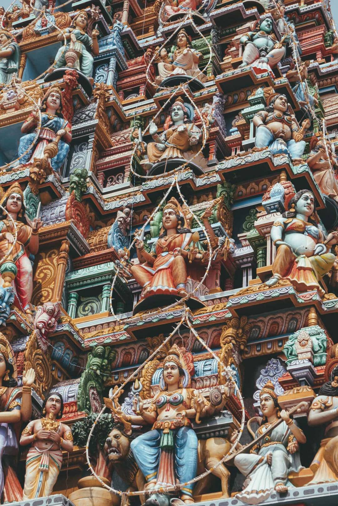 Close-up view of the colorful Sri Pathrakali Amman Kovil in Trincomalee, showcasing its temple tower adorned with detailed statues of deities and intricate carvings.