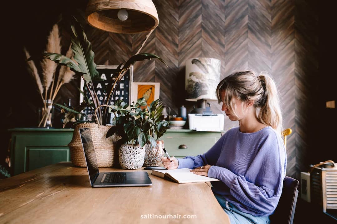how to start a blog girl working taking notes in front of laptop