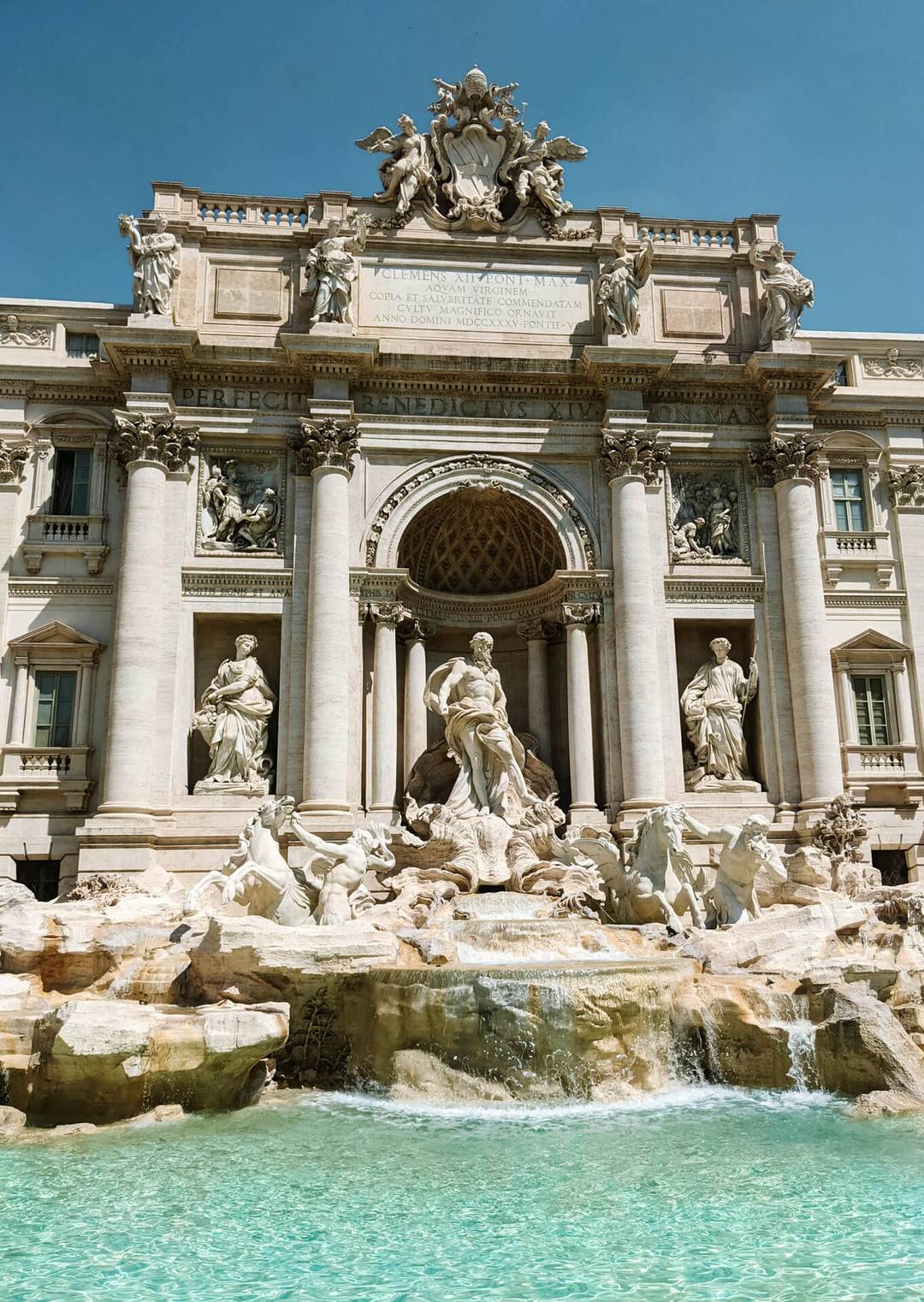 The Trevi Fountain in Rome, Italy, is a highlight of any Italy 7 day itinerary, featuring ornate Baroque sculptures and clear blue water with statues set against a grand stone building fa&ccedil;ade.