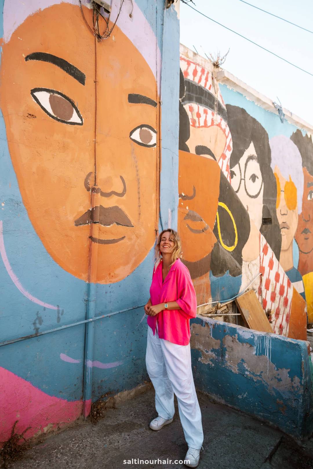 girl standing in front of street art amman jordan