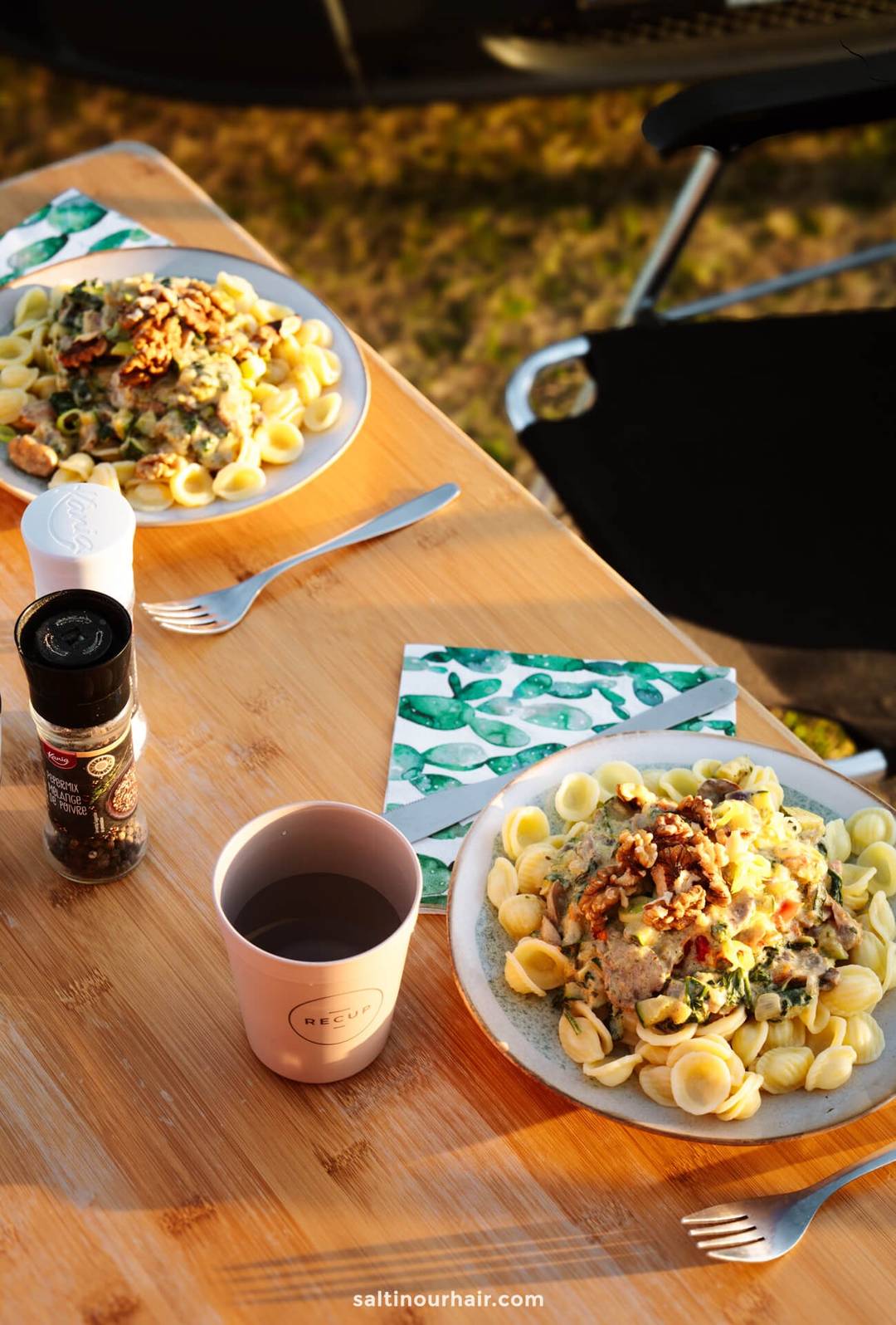 Plates of pasta and a cup of water on a table&mdash;perfect for fueling up before mapping out your Denmark itinerary.
