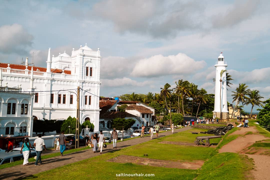 Visitors strolling past Meeran Jumma Mosque and the Galle Lighthouse in Galle Fort, Sri Lanka.
