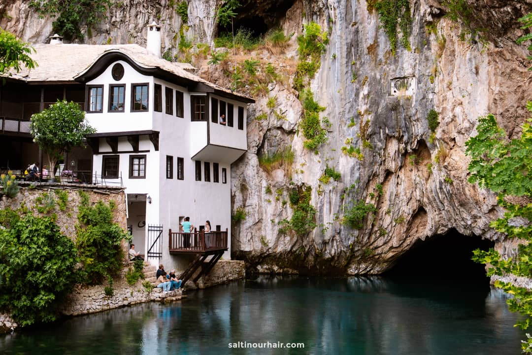 Blagaj Tekke Monastery built into a limestone cliff above a turquoise spring in Blagaj, Bosnia and Herzegovina.