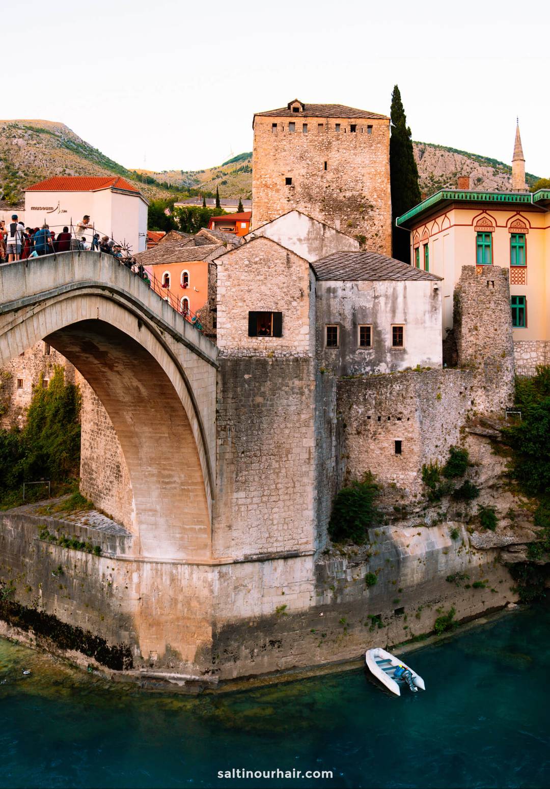 Tourists crossing Stari Most (Old Bridge) over the turquoise Neretva River in Mostar, Bosnia and Herzegovina.