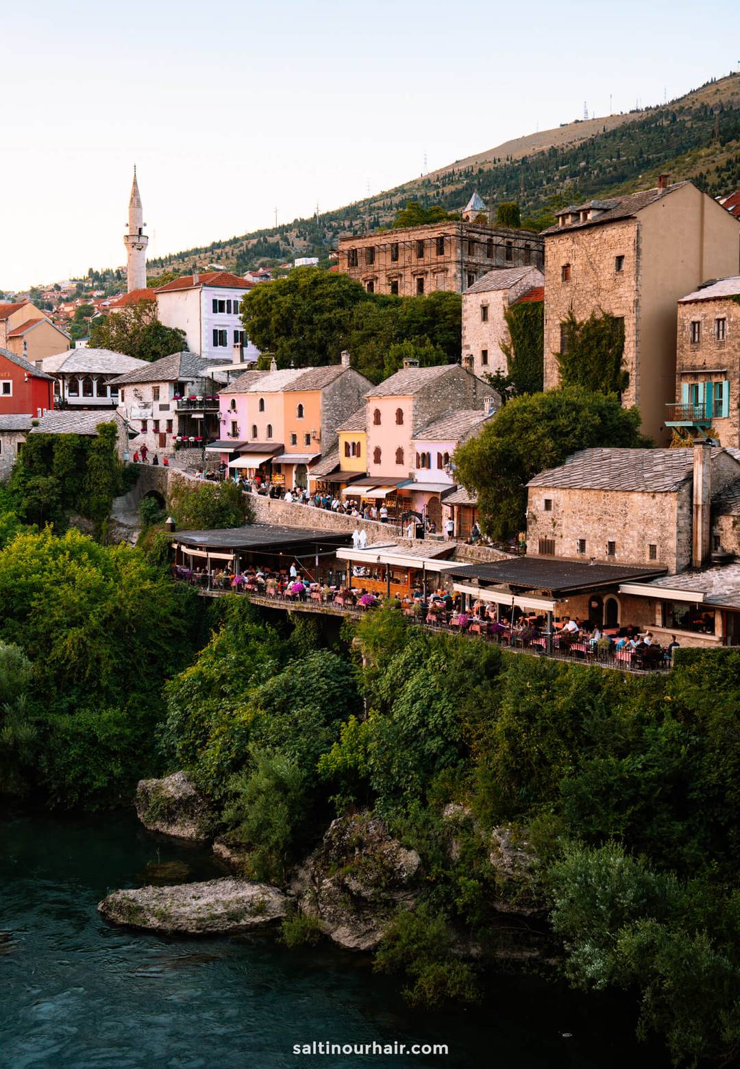Riverside restaurants and Ottoman stone buildings lining the Neretva River in Mostar